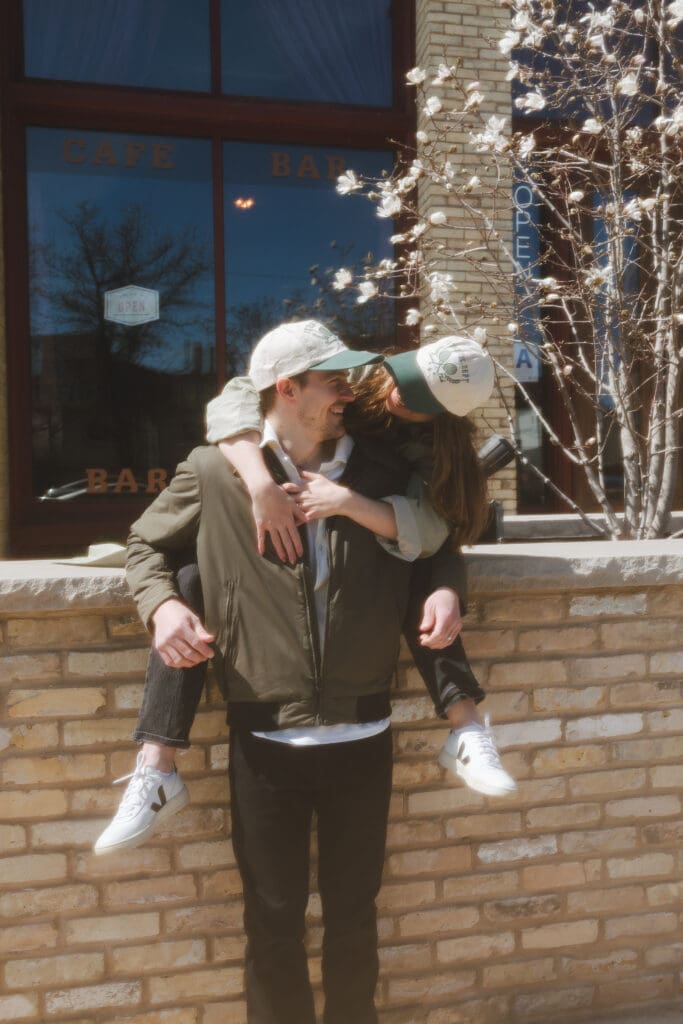 girl hugging guy from behind while they smile together