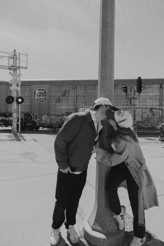couple sneaking a kiss in front of a passing train